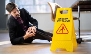 A concerned woman in business attire speaking with a slip and fall attorney in an office setting, both reviewing documents.